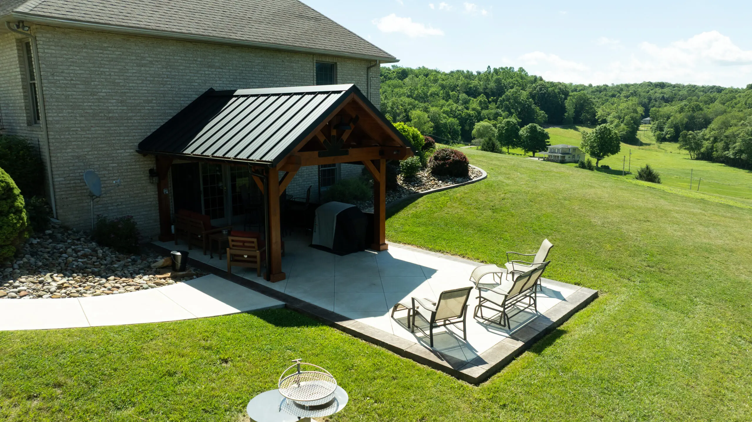 Timber pavilion on a poured patio beside a home