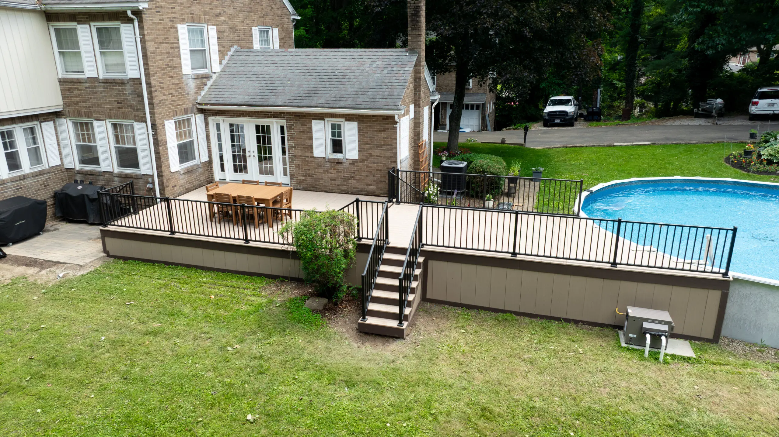 Composite deck with black railing beside an above-ground pool at an Ohio home