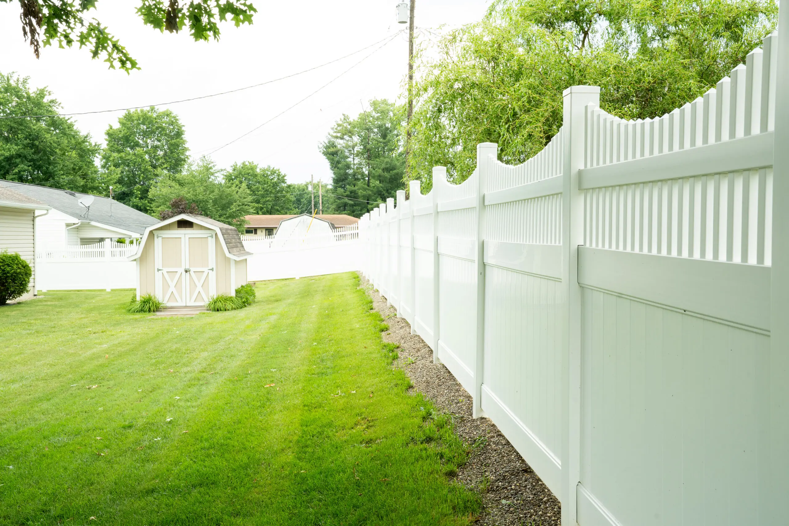 White vinyl privacy fence along a mown lawn